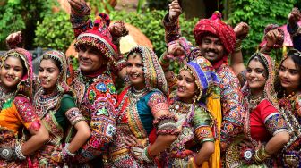 Peserta dari kelompok seni yang mengenakan pakaian tradisional berpose saat latihan tari Garba menjelang festival Navratri di Ahmedabad, India, Selasa (20/9/2022). [SAM PANTHAKY / AFP]