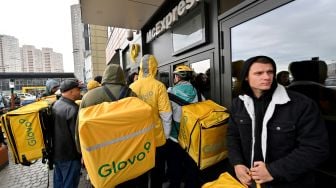 Kurir pengiriman makanan Glovo menunggu untuk mengambil pesanan di luar restoran McDonald di Kyiv, Ukraina, Selasa (20/9/2022). [Sergei SUPINSKY / AFP]