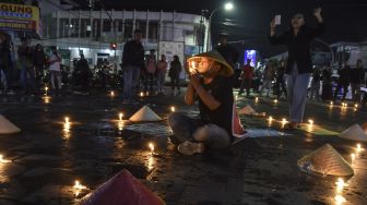 Mahasiswa yang tergabung gerakan Tasik Kelabu menggelar aksi teaterikal sambil menyalakan lilin di Taman Kota Tasikmalaya, Jawa Barat, Rabu (21/9/2022) malam. ANTARA FOTO/Adeng Bustomi
