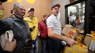 Kurir pengiriman makanan Glovo mengambil pesanan di sebuah restoran McDonald di Kyiv, Ukraina, Selasa (20/9/2022). [Sergei SUPINSKY / AFP]