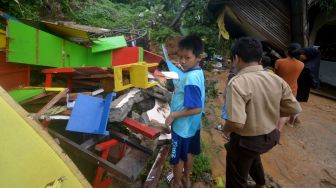 Sejumlah anak berada di depan bangunan sekolah PAUD yang hancur karena longsor di Batubusuk, Padang, Sumatera Barat, Kamis (22/9/2022). [ANTARA FOTO/Iggoy el Fitra/rwa].