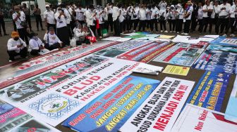 Massa yang tergabung dalam Forum Komunikasi Honorer Nakes & Non Nakes (FKHN) Indonesia melalukan aksi unjuk rasa di kawasan Patung Kuda, Monas, Jakarta Pusat, Kamis (22/9/2022). [Suara.com/Alfian Winanto]