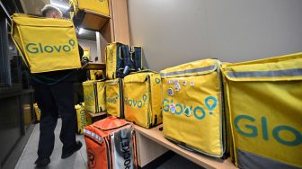 Deretan tas pengiriman para tergeletak di bangku saat para kurir menunggu pesanan makanan di sebuah restoran McDonald di Kyiv, Ukraina, Selasa (20/9/2022). [Sergei SUPINSKY / AFP]