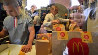 Kesibukan para karyawan McDonald menyiapkan pesanan makanan untuk dikirimkan ke pelanggan melalui kurir di sebuah restoran McDonald di Kyiv, Ukraina, Selasa (20/9/2022). [Sergei SUPINSKY / AFP]