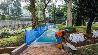 Pekerja menyelesaikan pembangunan jalur sepeda di kawasan Semanggi, Jakarta Pusat, Sabtu (24/9/2022). [Suara.com/Alfian Winanto]