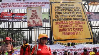 Massa gabungan dari Petani, Buruh dan Mahasiswa menggelar aksi unjuk rasa di depan Gedung DPR RI, Jakarta Pusat, Selasa (27/9/2022). [Suara.com/Alfian Winanto]