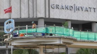 Pekerja menyelesaikan proyek revitalisasi Halte Transjakarta di Kawasan Bundaran HI, Jakarta Pusat, Selasa (27/9/2022). [Suara.com/Alfian Winanto]