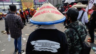Massa gabungan dari Petani, Buruh dan Mahasiswa menggelar aksi unjuk rasa di depan Gedung DPR RI, Jakarta Pusat, Selasa (27/9/2022). [Suara.com/Alfian Winanto]