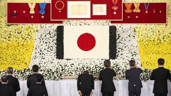 Para pejabat memberikan penghormatan di depan altar saat pemakaman kenegaraan mantan perdana menteri Jepang Shinzo Abe di Nippon Budokan, Tokyo, Jepang, Selasa (27/9/2022). [Takashi Aoyama / POOL / AFP]