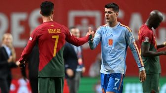 Penyerang Timnas Portugal, Cristiano Ronaldo (kiri) berjabat tangan dengan penyerang Timnas Spanyol, Alvaro Morata usai laga UEFA Nations League di Braga, Rabu (28/9/2022) dini hari WIB. [PATRICIA DE MELO MOREIRA / AFP]