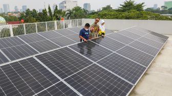 Pelajar melihat panel surya di SDN Ragunan 08 yang termasuk sekolah berkonsep net zero carbon di Ragunan, Jakarta Selatan, Kamis (29/9/2022). [Suara.com/Alfian Winanto]