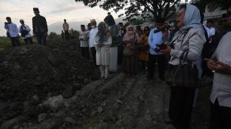 Warga memanjatkan doa saat berziarah di lokasi terdampak bencana gempa dan pencairan tanah atau likuefaksi di Kelurahan Balaroa, Palu, Sulawesi Tengah, Rabu (28/9/2022). [ANTARA FOTO/Mohamad Hamzah/rwa].