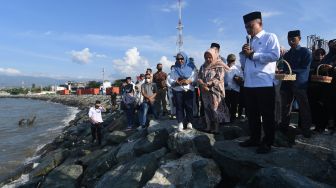 Wali Kota Palu Hadianto Rasyid (kanan) memanjatkan doa saat berziarah di lokasi terdampak bencana gempa dan tsunami di Kelurahan Talise di Palu, Sulawesi Tengah, Rabu (28/9/2022). [ANTARA FOTO/Mohamad Hamzah/rwa].