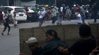 Sejumlah warga melempar petasan ke arah aparat kepolisian yang melakukan pengamanan saat proses eksekusi rumah di Makassar, Sulawesi Selatan, Kamis (29/9/2022). [ANTARA FOTO/Abriawan Abhe/YU]