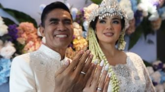 Catherine Wilson bersama suaminya Idham Mase menunjukan cincin kawin usai akad nikah di Jakarta, Sabtu (1/1). [ Suara.com/Oke Atmaja]