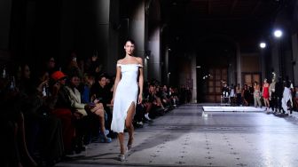 Model Bella Hadid tampil di catwalk dengan slip dress yang disemprot dengan kain Fabrican Spray-on selama peragaan busana Coperni Spring-Summer 2023 yang merupakan bagian dari Paris Fashion Week di Paris, Prancis, Jumat (30/9/2022). [JULIEN DE ROSA / AFP]
