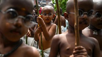 Anak-anak berpakaian menyerupai ikon kemerdekaan India Mahatma Gandhi dalam sebuah acara untuk memperingati kelahirannya kelahirannya di Chennai, India, Sabtu (1/10/2022). [Arun SANKAR / AFP]