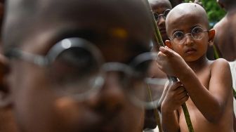 Anak-anak berpakaian menyerupai ikon kemerdekaan India Mahatma Gandhi dalam sebuah acara untuk memperingati kelahirannya kelahirannya di Chennai, India, Sabtu (1/10/2022). [Arun SANKAR / AFP]