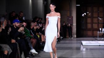 Model Bella Hadid tampil di catwalk dengan slip dress yang disemprot dengan kain Fabrican Spray-on selama peragaan busana Coperni Spring-Summer 2023 yang merupakan bagian dari Paris Fashion Week di Paris, Prancis, Jumat (30/9/2022). [JULIEN DE ROSA / AFP]
