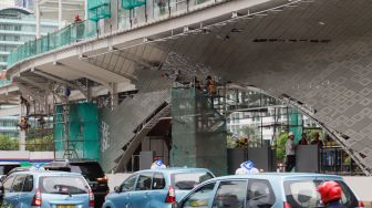 Pekerja menyelesaikan proyek revitalisasi Halte Transjakarta Bundaran HI, Jakarta Pusat, Selasa (4/10/2022). [Suara.com/Alfian Winanto]