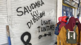 Sejumlah coretan berisi kekecewaan menghiasi dinding Stadion Kanjuruhan Malang, Jawa Timur, Selasa (4/10/2022). Mereka minta agar kasus Tragedi Kanjuruhan yang menelan lebih dari 100 orang meninggal dunia diusut tuntas. [Suara.com/Dimas Angga]