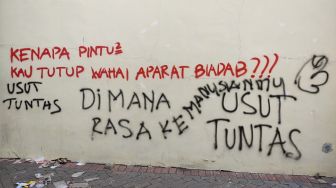 Sejumlah coretan berisi kekecewaan menghiasi dinding Stadion Kanjuruhan Malang, Jawa Timur, Selasa (4/10/2022). Mereka minta agar kasus Tragedi Kanjuruhan yang menelan lebih dari 100 orang meninggal dunia diusut tuntas. [Suara.com/Dimas Angga]