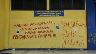 Sejumlah coretan berisi kekecewaan menghiasi dinding Stadion Kanjuruhan Malang, Jawa Timur, Selasa (4/10/2022). Mereka minta agar kasus Tragedi Kanjuruhan yang menelan lebih dari 100 orang meninggal dunia diusut tuntas. [Suara.com/Dimas Angga]