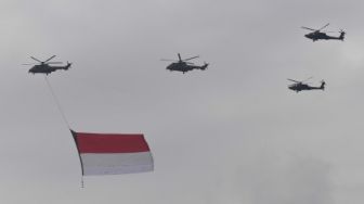 Helikopter Tri Matra Flight membawa bendera Merah Putih saat flypast perayaan HUT ke-77 TNI di Langit Monas, Jakarta, Rabu (5/10/2022). [ANTARA FOTO/Wahyu Putro A/nz]