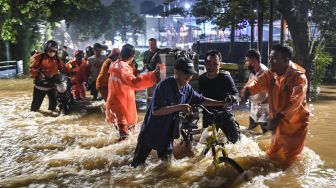 Petugas Penanganan Prasarana dan Sarana Umum (PPSU) mengimbau pengendara mobil saat menerjang banjir di kawasan Jeruk Purut, Jakarta Selatan, Kamis (6/10/2022). [ANTARA FOTO/M Risyal Hidayat/YU]