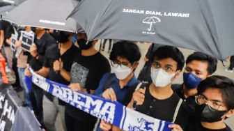 Pegiat Hak Asasi Manusia (HAM) membawa poster dan spanduk Arema saat aksi Kamisan di depan Istana Merdeka, Jakarta Pusat, Kamis (6/10/2022).
[Suara.com/Alfian Winsnto]