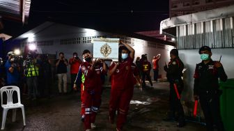 Personel penyelamat membawa peti mati korban korban penembakan massal di kamar mayat rumah sakit di Udon Thani, Thailand, Kamis (6/10/2022). [Manan VATSYAYANA / AFP]
