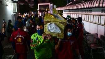 Personel penyelamat membawa peti mati korban korban penembakan massal di kamar mayat rumah sakit di Udon Thani, Thailand, Kamis (6/10/2022). [Manan VATSYAYANA / AFP] 