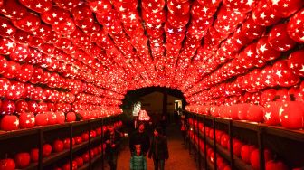 Pengunjung melihat ukiran labu di pameran Great Jack O'Lantern Blaze di Van Cortlandt Manor, Croton-on-Hudson, New York, Amerika Serikat, Sabtu (8/10/2022). [Bryan R. Smith / AFP]
