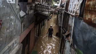 Warga berjalan melintasi banjir di permukiman penduduk kawasan Rawajati, Jakarta, Senin (10/10/2022). ANTARA FOTO/Aprillio Akbar/aww].