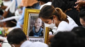 Keluarga korban berkumpul untuk doa bersama dan upacara keagamaan di luar tempat penitipan anak, yang menjadi lokasi penembakan massal di kota Uthai Sawan, Nong Bua Lam Phu, Thailand, Minggu (9/10/2022). [Lillian SUWANRUMPHA / AFP]