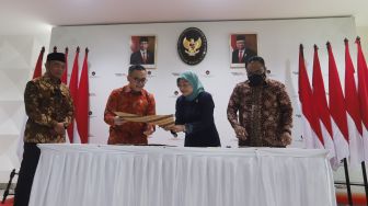 Menteri Koordinator Bidang Pembangunan Manusia dan Kebudayaan Muhadjir Effendy (kiri)  Menteri Pendayagunaan Aparatur Negara dan Reformasi Birokrasi (PANRB) Abdullah Azwar Anas (kanan), Menteri Ketenagakerjaan Ida Fauziyah (dua kanan) dan Menteri Agama Yaqut Cholil Qoumas (kanan) menandatangani Surat Keputusan Bersama (SKB) Libur Nasional dan Cuti Bersama 2023 di Kantor Kemenko PMK, Jakarta, Selasa (11/10/2022). [Suara.com/Oke Atmaja]
