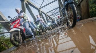 Sejumlah pengendara roda dua antre saat akan melintasi jembatan sementara di Sukajaya, Lebak, Banten, Selasa (11/10/2022).  ANTARA FOTO/Muhammad Bagus Khoirunas