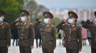 Para tentara memberi penghormatan di depan patung pemimpin Korea Utara Kim Il Sung dan Kim Jong Il di Bukit Mansu, Pyongyang, Korea Utara, Senin (10/10/2022). [KIM Won Jin / AFP]
