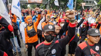 Massa buruh menggelar aksi unjuk rasa di Kawasan Patung Kuda, Jakarta Pusat, Rabu (12/10/2022). [Suara.com/Alfian Winanto]