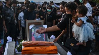 Keluarga dan kerabat berkabung di samping peti mati korban penembakan massal selama upacara kremasi di Na Klang, Provinsi Nong Bua Lam Phu, Thailand, Selasa (11/10/2022). [Lillian SUWANRUMPHA / AFP]
