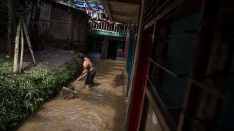 Warga membersihkan lumpur saat banjir menggenangi permukiman di Taman Harapan, Cawang, Kramat Jati, Jakarta Timur, Rabu (12/10/2022). [ANTARA FOTO/Sigid Kurniawan/foc].