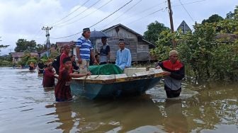 Sejumlah warga membawa jenazah untuk dimakamkan dengan menggunakan perahu saat melintasi banjir di Teluk Barak, Kelurahan Kedamin Hilir, Kecamatan Putussibau Selatan, Kabupaten Kapuas Hulu, Kalimantan Barat, Selasa (11/10/2022).  ANTARA FOTO/Teofilusianto Timotius