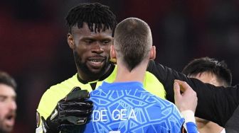 Kiper Omonia Nicosia, Francis Uzoho (kiri) bercengkerama dengan kiper Manchester United, David de Gea usai laga Liga Europa di Old Trafford, Manchester, Jumat (14/10/2022) dini hari WIB. [Oli SCARFF / AFP]