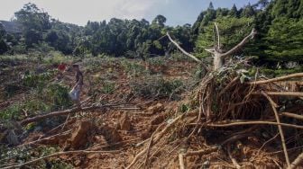 Warga melintasi reruntuhan material longsor di Desa Gunung Geulis, Sukaraja, Kabupaten Bogor, Jawa Barat, Jumat (14/10/2022). [ANTARA FOTO/Yulius Satria Wijaya/rwa].