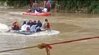 Jembatan Cimancak Ambruk, Warga Lebak Seberangi Sungai dengan Perahu