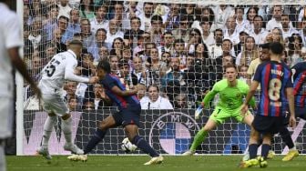 Gelandang Real Madrid Federico Valverde (kiri) mencetak gol kedua timnya selama pertandingan sepak bola Liga Spanyol antara Real Madrid melawan Barcelona di Santiago Bernabeu, Minggu (16/10/2022) malam WIB.PIERRE-PHILIPPE MARCOU/AFP

