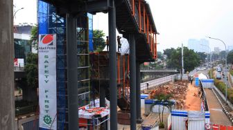 Pekerja menyelesaikan pembangunan jembatan penyeberangan orang (skywalk) yang menghubungkan Stasiun Kebayoran Lama dan Halte Transjakarta di Kebayoran, Jakarta, Selasa (18/10/2022).  ANTARA FOTO/Reno Esnir