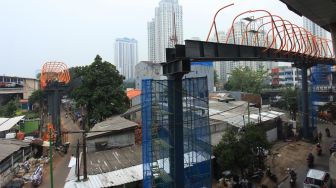 Pekerja menyelesaikan pembangunan jembatan penyeberangan orang (skywalk) yang menghubungkan Stasiun Kebayoran Lama dan Halte Transjakarta di Kebayoran, Jakarta, Selasa (18/10/2022).  ANTARA FOTO/Reno Esnir