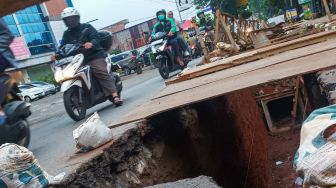 Pengendara melintas disamping proyek galian saluran di Pejaten, Pasar Minggu, Jakarta Selatan, Selasa (18/10/2022). [Suara.com/Alfian Winanto]