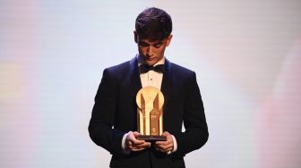 Gelandang Barcelona, Gavi berpose dengan Trofi Kopa dalam seremonial Ballon d'Or 2022 di Theatre du Chatelet, Paris, Prancis, Selasa (18/10/2022) dini hari WIB. [FRANCK FIFE / AFP]